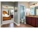 Bright bathroom with wooden floors and vanity, showcasing the bedroom through the doorway at 5799 Linen Bluff Pl, Leesburg, FL 34748