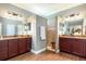 Luxurious bathroom with double vanity, granite countertops, and tiled shower with glass door at 5799 Linen Bluff Pl, Leesburg, FL 34748