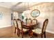 Elegant dining room with ornate wood table and chairs, decorative chandelier, and hardwood floors at 5799 Linen Bluff Pl, Leesburg, FL 34748