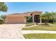 Charming single-story home with a well-manicured lawn, two-car garage, and inviting front entrance at 5799 Linen Bluff Pl, Leesburg, FL 34748