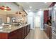 Spacious kitchen with granite counters, dark cabinets, stainless appliances and an open design connecting to dining area at 5799 Linen Bluff Pl, Leesburg, FL 34748
