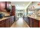 Open kitchen featuring wood floors, granite counters, modern appliances, and sliding glass doors leading to a pool at 5799 Linen Bluff Pl, Leesburg, FL 34748