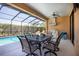 Screened-in patio area with seating and a dining table overlooking the inviting swimming pool at 5799 Linen Bluff Pl, Leesburg, FL 34748