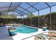 Inviting screened-in pool area, complete with outdoor furniture and poolside planters at 5799 Linen Bluff Pl, Leesburg, FL 34748