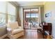 Bright sun room with view of the pool featuring a comfortable armchair, desk, and natural light at 5799 Linen Bluff Pl, Leesburg, FL 34748