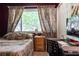 Cozy bedroom with a window view, featuring a comfortable bed and a functional workspace at 5961 Windhover Dr # F05, Orlando, FL 32819