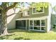 Exterior of the home featuring a screened-in patio and a large tree at 5961 Windhover Dr # F05, Orlando, FL 32819