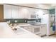Bright kitchen featuring white cabinets and modern appliances at 5961 Windhover Dr # F05, Orlando, FL 32819