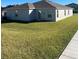 Green backyard featuring a lawn and partial view of the home's exterior at 604 Sarner Pass Way, Winter Haven, FL 33881