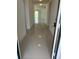 Bright hallway with glossy tile flooring leading to a living area with sliding glass doors at 604 Sarner Pass Way, Winter Haven, FL 33881
