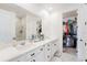 Bathroom with a dual sink vanity, large mirror and walk-in shower, providing a luxurious feel at 7409 Inlet Pt, Celebration, FL 34747