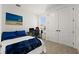 A well-lit room features a large bed, a desk with a computer setup, and ample closet space at 7409 Inlet Pt, Celebration, FL 34747