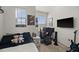 This room showcases a comfortable bed, natural light from two windows, and a gaming setup at 7409 Inlet Pt, Celebration, FL 34747