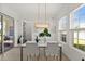 Bright dining room with a view to the patio with modern light fixture and white woven chairs at 7409 Inlet Pt, Celebration, FL 34747