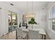 Bright dining room with a view to the patio with modern light fixture and white woven chairs at 7409 Inlet Pt, Celebration, FL 34747