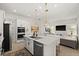 Open kitchen with an island, stainless steel appliances, and white cabinets with black hardware, open to living area at 7409 Inlet Pt, Celebration, FL 34747