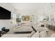 Bright living room featuring white furniture, neutral decor, large windows, and a TV mounted on the wall at 7409 Inlet Pt, Celebration, FL 34747