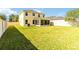 A spacious, grassy backyard features a two-story home and a screened patio, surrounded by a privacy fence at 7545 Azalea Cove Cir, Orlando, FL 32807