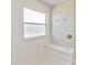 Bright bathroom shower featuring white tile, a built-in seat, and a window for natural light at 7545 Azalea Cove Cir, Orlando, FL 32807