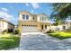 Inviting two-story yellow home with a well-manicured lawn and a spacious two-car garage at 7545 Azalea Cove Cir, Orlando, FL 32807