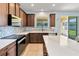 Bright kitchen featuring dark wood cabinets, marble countertop island, and view to the outside at 7545 Azalea Cove Cir, Orlando, FL 32807