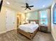 Comfortable bedroom features a ceiling fan, ensuite, and wood like floors at 8001 Sand Bar Dr, Kissimmee, FL 34747