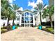 Stunning exterior shot of a modern building, framed by palm trees and vibrant blue planters at 8001 Sand Bar Dr, Kissimmee, FL 34747