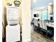 Laundry room with stackable washer and dryer, leading to a dining area and living room at 8001 Sand Bar Dr, Kissimmee, FL 34747