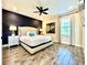 Serene main bedroom with a king-sized bed, dark accent wall, and a modern ceiling fan at 8001 Sand Bar Dr, Kissimmee, FL 34747