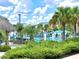 Relaxing pool area with lush landscaping, a tiki bar, and comfortable seating under cabanas and palm trees at 8001 Sand Bar Dr, Kissimmee, FL 34747