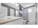 Bright bathroom with a white vanity, a large mirror, and a shower with a patterned curtain at 8160 Sun Palm Dr, Kissimmee, FL 34747