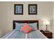 Detailed view of bedroom highlighting bedspread, headboard, artwork, and bedside table with lamp at 8160 Sun Palm Dr, Kissimmee, FL 34747