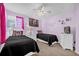 Inviting bedroom with twin beds, whimsical decor, a ceiling fan and soft, lilac walls at 8160 Sun Palm Dr, Kissimmee, FL 34747