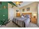Inviting bedroom featuring a bed with decorative pillows, wood furniture, and a unique green accent wall at 8160 Sun Palm Dr, Kissimmee, FL 34747