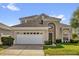 Charming two-story home featuring a well-manicured lawn and an attached two-car garage at 8160 Sun Palm Dr, Kissimmee, FL 34747