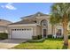 Charming two-story home featuring a well-manicured lawn and an attached two-car garage at 8160 Sun Palm Dr, Kissimmee, FL 34747