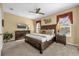 Spacious main bedroom with a ceiling fan, TV, and bedside lamps at 8160 Sun Palm Dr, Kissimmee, FL 34747