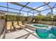 This screened pool area has a spa, comfortable lounge chairs, and privacy landscaping at 8160 Sun Palm Dr, Kissimmee, FL 34747