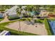 Aerial view of a sand volleyball court with nearby swimming pool and building at 8160 Sun Palm Dr, Kissimmee, FL 34747