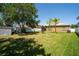 Spacious backyard with lush lawn, trees, white fence and a storage shed on a sunny day at 8856 Hastings Beach Blvd, Orlando, FL 32829