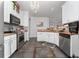Well-lit kitchen with white cabinets, stainless steel appliances, and a decorative chandelier at 8856 Hastings Beach Blvd, Orlando, FL 32829