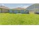Green backyard with a view of the home's exterior and a patio area for outdoor relaxation at 917 Jackson Ave, Davenport, FL 33837