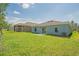 Lush backyard with an exterior view of two homes, featuring sliding glass doors and an AC unit at 917 Jackson Ave, Davenport, FL 33837