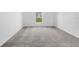 Neutral bedroom with a plush carpet and natural light streaming through the window at 917 Jackson Ave, Davenport, FL 33837