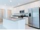 Bright, modern kitchen with stainless steel appliances, a central island, and ample white cabinet space at 921 Jackson Ave, Davenport, FL 33837