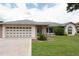 Charming single-story home featuring a well-manicured lawn and attached two-car garage at 935 Amy Ridge Ct, Kissimmee, FL 34747