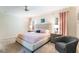 Bright bedroom features neutral colors, soft carpet, and a comfortable reading chair at 9963 Hartford Maroon Rd, Orlando, FL 32827