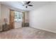 Bright bedroom featuring a ceiling fan, window with decorative curtains, and neutral carpet at 9963 Hartford Maroon Rd, Orlando, FL 32827