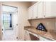 Functional office nook featuring granite counters, white cabinets and easy access to a bedroom at 9963 Hartford Maroon Rd, Orlando, FL 32827