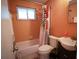 Well-lit bathroom with an orange tub and patterned shower curtain at 1 Cosmos Dr, Orlando, FL 32807